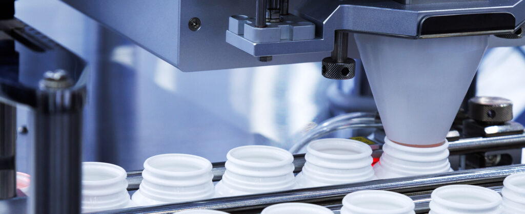 Packaging machine filling bottles on assembly line