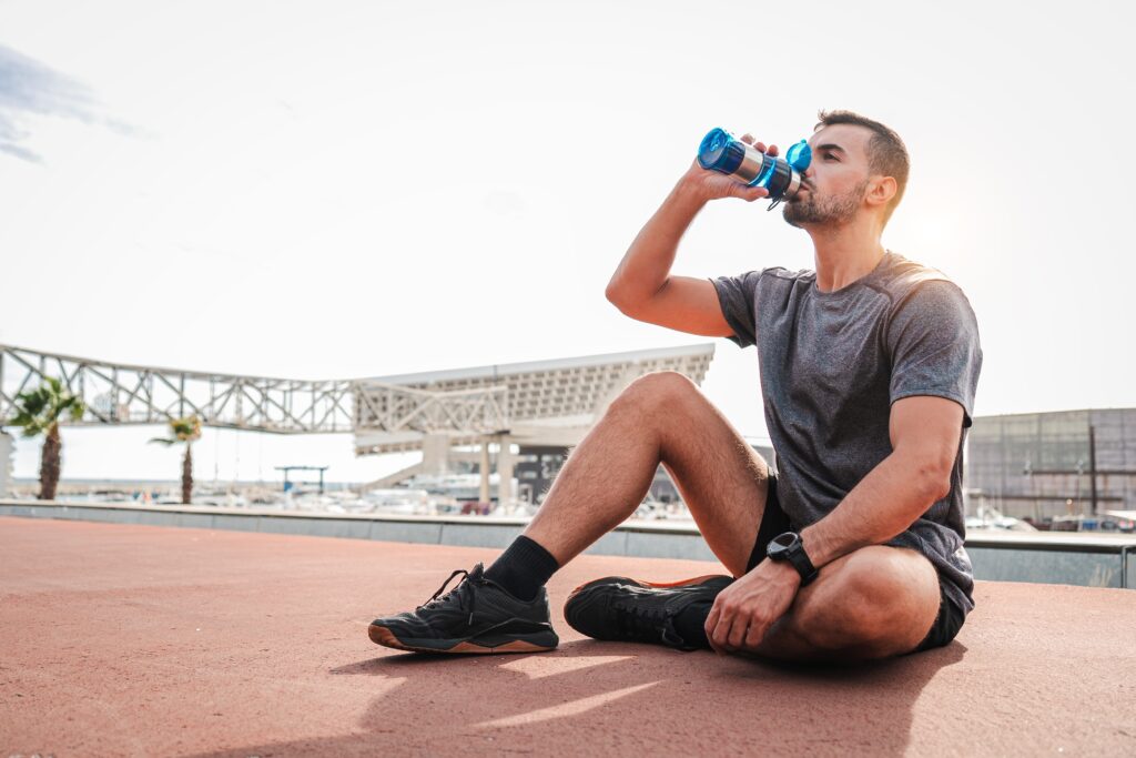 Male athlete drinking a supplement drink for recovery