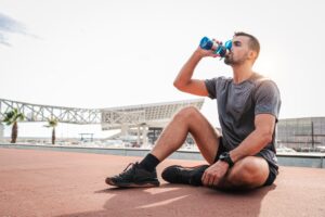 Male athlete drinking a supplement drink for recovery