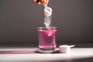 Woman pouring a creatine drink supplement