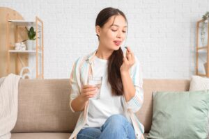 Woman taking a daily immune support supplement as part of her everyday wellness routine