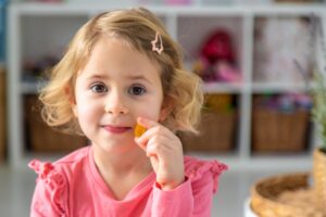 Mother giving her child a clean label vitamin gummy supplement as part of their morning routine