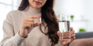Woman taking a multi benefit supplement formula as part of her daily mood and metabolism wellness routine